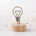 Bulb-shaped metal wire photo clip holder with a natural round wooden base stand - Light Bulb