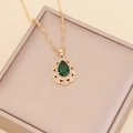 Close-up of gold water drop necklace with green gemstone and micro-pave diamonds - Malachite green