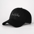Detail of Good Vibes white embroidery on a premium black cotton baseball cap surface - Black