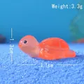 Detailansicht der orangefarbenen Harzschildkröte auf blauem Sand mit 3,1 cm Länge - Leuchtendes Orange