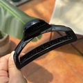 Detailed view of a 10cm black glossy butterfly hair claw clip held in hand - Glossy Black