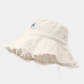 Gros plan détaillé d'un bob en toile crème avec bords effilochés et écusson Brooklyn - Taille unique / Beige