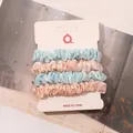 Detailed view of four satin silk scrunchies in blue and pink on display card - Sky Blue and Ivory