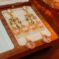 Primer plano de pendientes vintage con borlas y gemas rosas de gota en caja de madera - Aguja de Plata - Pendientes de Borla de Gota de Agua Rosa
