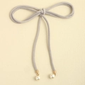 Detail of grey velvet bow belt featuring elegant white pearl pendants and golden metal caps - Gray