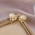Elegant daisy stud earrings with white petals, pearls, and crystals on a soft background - White Daisy / White