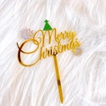Detailed close-up of gold acrylic Merry Christmas cake topper with green glitter hat and snowflake - Small Christmas Tree Merry Christmas