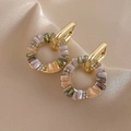 Détail de créoles dorées vintage avec zircons colorés sur tissu en soie beige - Boucles d'oreilles créoles en zircon doré