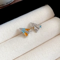 Makroaufnahme von silbernen Papierflieger-Ohrringen mit orangefarbenen Emaille-Sternen - Papierflieger und Stern Kombination (Silber-Blau-Orange)