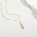 Elegante collana con ciondolo MAMA dorato e pietre preziose su sfondo bianco - Lettera MAMA