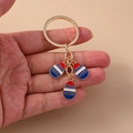 Detail of red white and blue enamel star charms on a gold keychain holder - Red Blue Egg