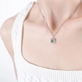 Collana d'argento con pietra verde quadrata e bordo ritorto indossata da una modella - Collana color acciaio con pietra di vetro verde