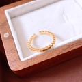 Detailaufnahme eines vergoldeten Perlenrings auf dem Samtfutter einer Schmuckschatulle - Offener Perlenstil / Gold