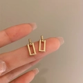 Elegant gold rectangular stud earrings held by hand against a soft beige background - Gold Square Stud Earrings