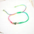 Detail of adjustable colorful braided bracelet with a heart-shaped green zircon charm - Colorful