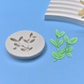 Detail showing grey silicone leaf mold and green finished fondant leaf on blue background - Leaf Pattern Style (3)