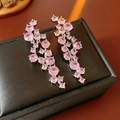 Vista macro de pendientes de borla con circón rosa en una caja de joyería negra texturizada - Poste de pendiente de plata - Plata - Rosa / Plata-Rosa