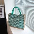 Jute tote bag with green wavy patterns and round rope handles in natural sunlight - Green