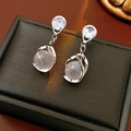 Macro shot of silver drop earrings with moonstone and cubic zirconia on a jewelry box - Silver (Silver Pin)