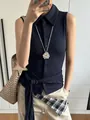 Close-up of a silver petal flower pendant necklace paired with a navy blue polo shirt - Silver Large Daisy Pendant Necklace
