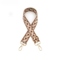 Détail d'une bandoulière à motif géométrique avec boucles et mousquetons dorés en métal - Quincaillerie Dorée / Marron et Blanc
