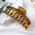 Large amber tortoiseshell hair claw clip in a minimalist geometric bone-shaped design - Transparent Leopard Print