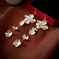 Détail de boucles d'oreilles longues à fleurs avec pétales argentés et accents dorés - Crochet d'Oreille à Pampille Fleur Dorée