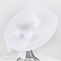Elegant wide brim straw sun hat in white with a large decorative bow on a metal stand - One Size / White