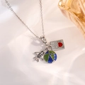 Macro shot of silver travel charms including an airplane, globe, and Passport pendant - Silver Airplane Heart Passport Style