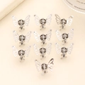 Detailed top view of 10 mini silver metal butterfly hair clips arranged on beige background - Silver 10Pcs Set