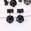 Vista macro de pendientes de bola de cristal azul oscuro con detalles de lazo negro - Azul marino