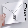Macro shot of silver angel wing pendant necklace with pavé cubic zirconia inlay - 1077 Angel Wings Pave Zirconia Necklace