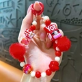 Bijou de téléphone fait main avec pompons rouges et perle motif vache sur porte-clés - Rouge