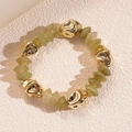 Detalle de cuentas de acrílico verde y cuentas metálicas doradas en una pulsera elástica - Pulsera-Verde Oscuro