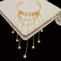 Detalle de una gargantilla chapada en oro con colgantes de estrellas y borlas en capas - Estilo de Estrella Dorada / Dorado