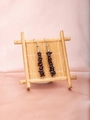 Deep red garnet stone earrings with silver hooks on bamboo stand over silk background - Garnet
