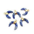 Close-up of five crescent-shaped lapis lazuli pendants with golden metal wrap on white backdrop - Blue Spot Stone