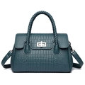 Dark green crocodile pattern handbag with braided handle and metal lock on white background - Blue