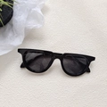 Trendy zwarte retro cat-eye zonnebril voor heren op een beige getextureerde achtergrond - Zwart en Grijs