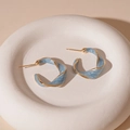 Detailweergave van lichtblauwe emaille gedraaide C-vormige oorbellen met gouden rand - Blauw Emaille Gedraaide C-Vorm (S925 Zilveren Pin)