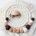 Beech wood pacifier clip with BABY letters and brown silicone beads on a tassel mat - Coffee