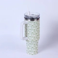 Detail of 40oz stainless steel tumbler with white handle and floral daisy pattern - All-over Daisy/Light Green