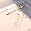 Detalle del llavero de lazo acrílico de 9,5 cm con colgante de mariposa iridiscente y perlas - Colgante de Mariposa de Acrílico Blanco