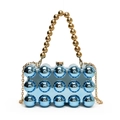 Close-up of blue acrylic shell bag featuring golden beaded handle and chain strap - Blue