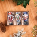 Dettaglio di tre ornamenti schiaccianoci in legno con pigne su sfondo effetto legno - Stile D Confezione da 9