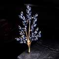 Detailed close-up of a golden branch brooch featuring elegant blue marquise-cut crystals - Champagne Gold - Blue