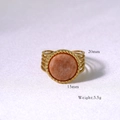 Dettaglio macro di un anello dorato a strati con pietra naturale arancione e misure - Pietra del sole