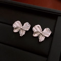 Detailansicht silberner Schleifenohrringe mit funkelnden Strasssteinen auf Schmuckbox - 49# Silberstift - Silberne Strass-Schleifen-Ohrstecker