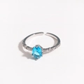 Macro detail of silver open ring with oval blue zircon and pavé diamond band accents - Light Blue Gemstone Silver Plated