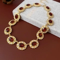 Dettaglio di una collana vintage dorata con pietre rosse ovali e decorazioni floreali - Collana Rossa